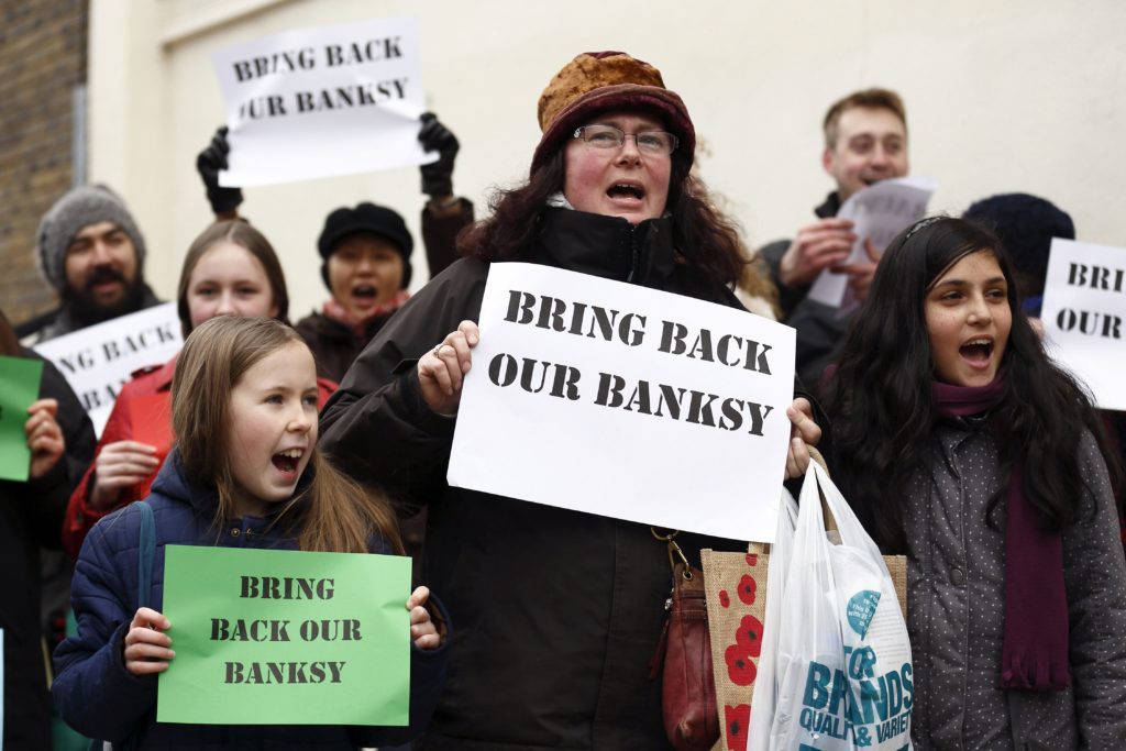 Bilde av protesterende gamle og unge med paroler Get Back Our Banksy